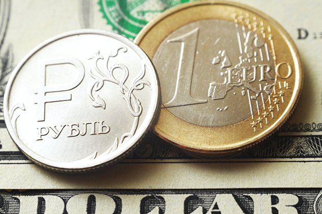 Монеты номиналом один рубль и один евро на банкноте один доллар США